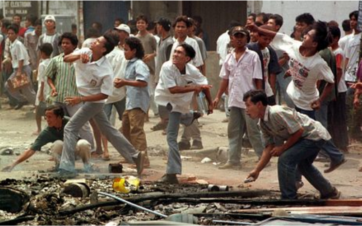 Rioters throwing rocks at ethnic-Chinese owned stores in Medan, Indonesia. (1998) Credit: AP Photo/Charles Dharapak